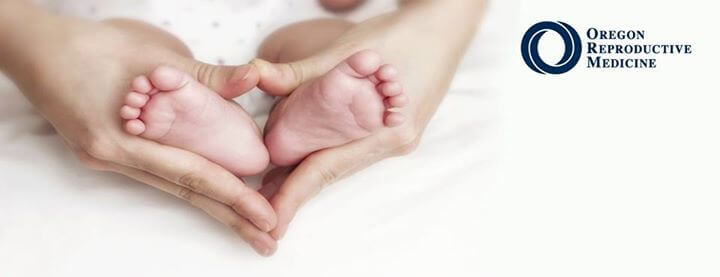 photo of adult hands cradling baby feet