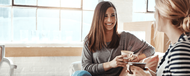 photo of women laughing over coffee