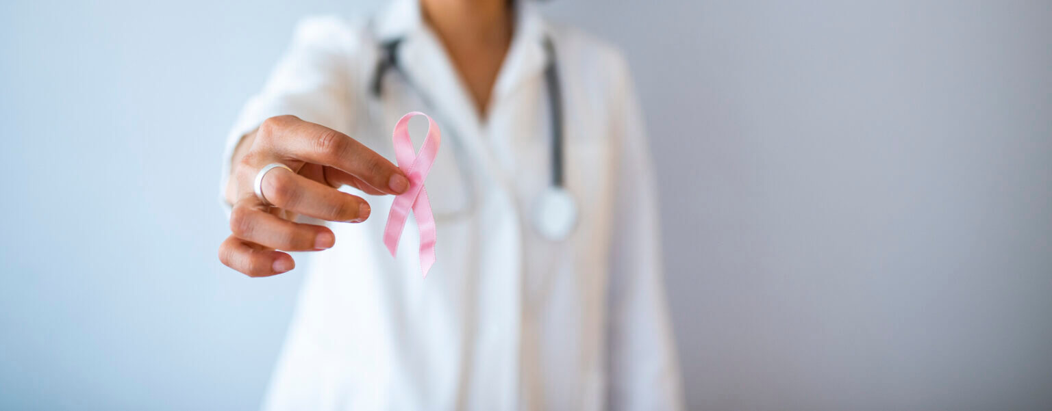 doctor with pink ribbon fertility after breast cancer