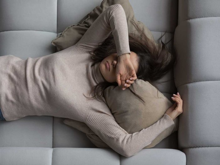 Peaceful girl lying on back on comfortable couch at home