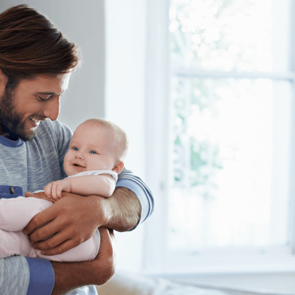 Dad holding smiling baby